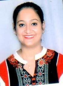 Portrait of Dr. Kapoor wearing traditional attire with academic books in background